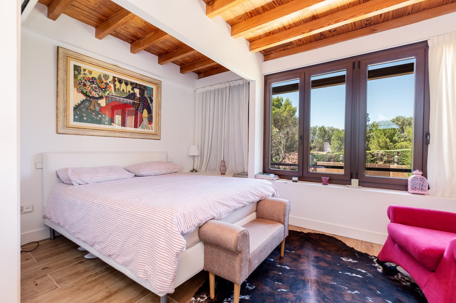 Suite con vigas de madera vistas, cama king y vistas al jardín