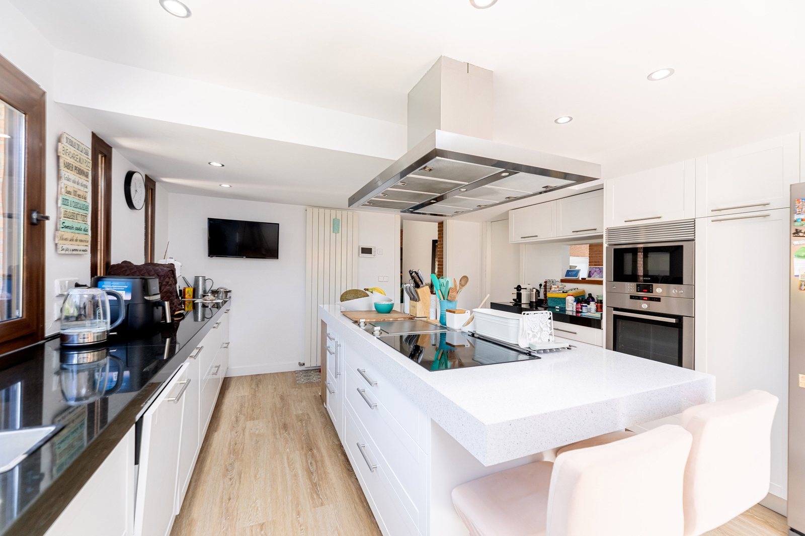 Cocina con isla blanca y encimera de cuarzo, vista panorámica